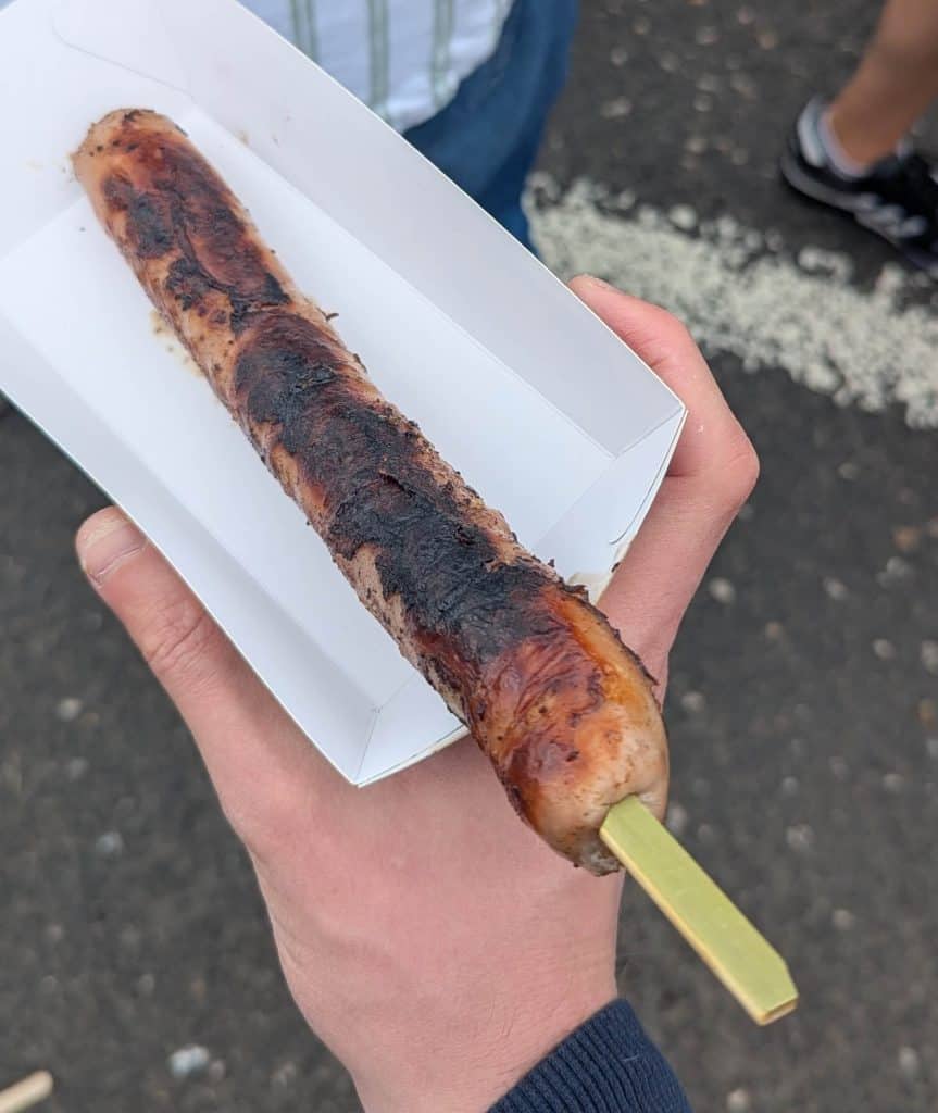 A grilled Geordie Bangers sausage served on a wooden stick at Seaham Food Festival