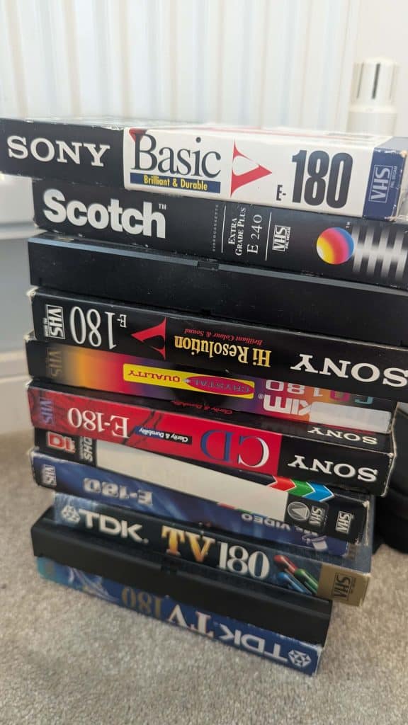A tall stack of branded VHS tapes including Sony Basic 180, Scotch E240, and TDK TV180.