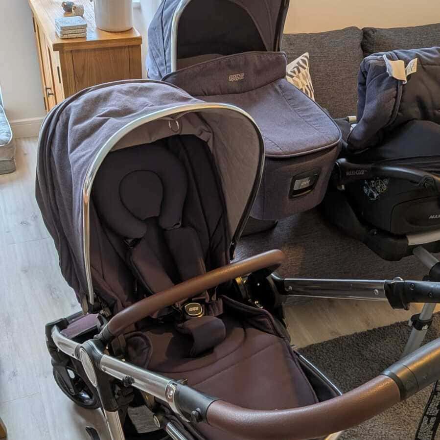 Mamas and Papas Ocarro pram chassis with seat unit set up indoors alongside matching carrycot attachment.